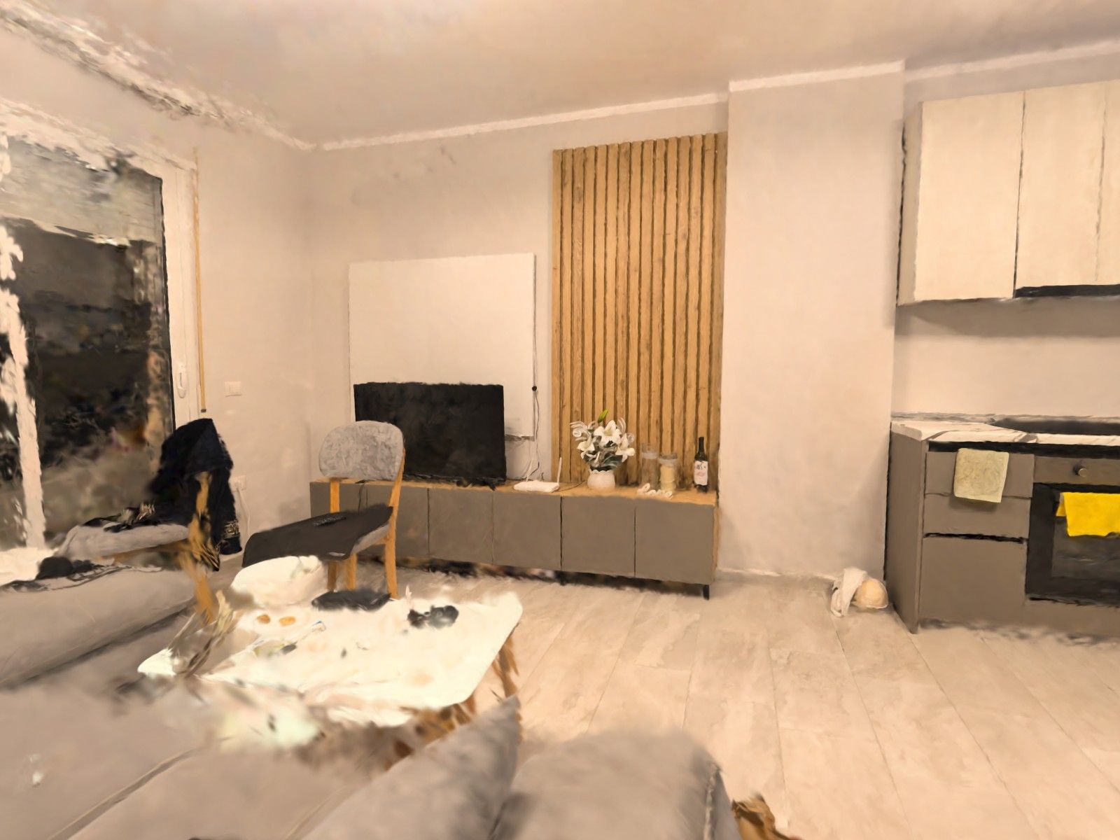 A living room with a sofa, coffee table and TV next to the kitchen — a frame from a 3D tour filmed on a phone